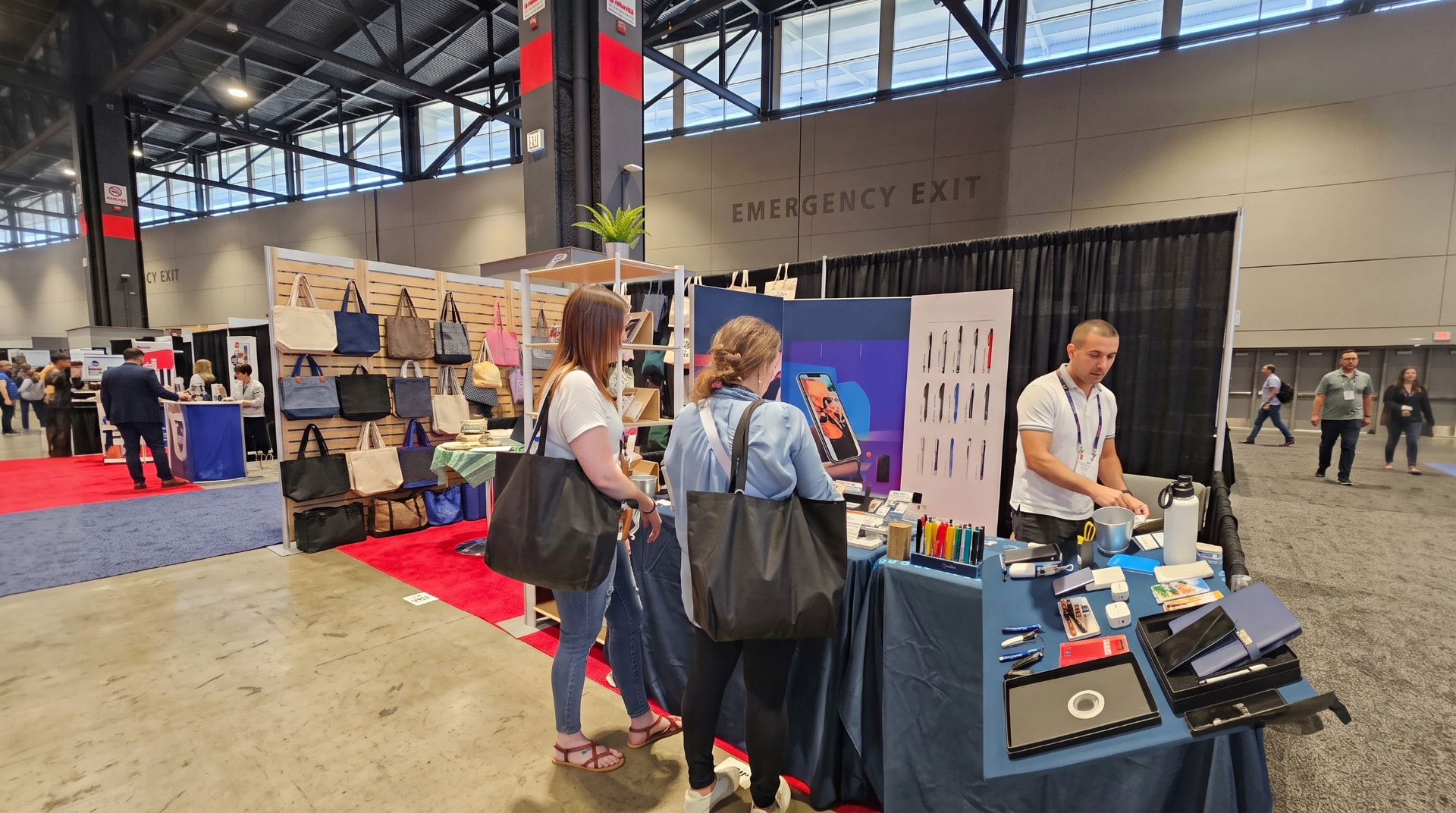 Custom branded tech promotional products arranged on an ASI Show booth table
